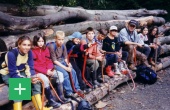 Kinder sitzen auf einem Baumstamm <span class="copy">&copy; HolzKompetenzZentrum Rheinland</span>