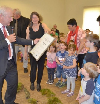 Der stellv. Naturpark-Vorsitzende Aloysius Söhngen überreicht den Kita-Kindern die Urkunde.